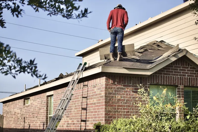 Professional roofer working on a residential roof in Village Hill
